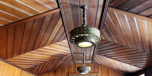 Circular lamp on a wooden planked ceiling.